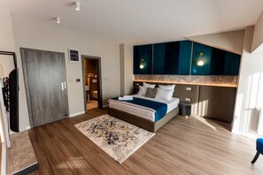 A modern bedroom with a large bed, a walk-in closet, and a bathroom visible through an open door. - Villa Bijoux (Ploiesti)