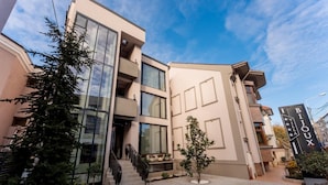 A modern building with large windows, a staircase, and a sign that reads "BIJOUX". - Villa Bijoux (Ploiesti)
