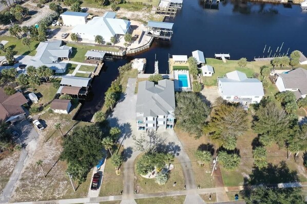 An aerial view of a residential area with houses, a dock, and a marina.