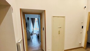 Ein Zimmer mit Holzboden, weißer Tür und weißem Tisch.