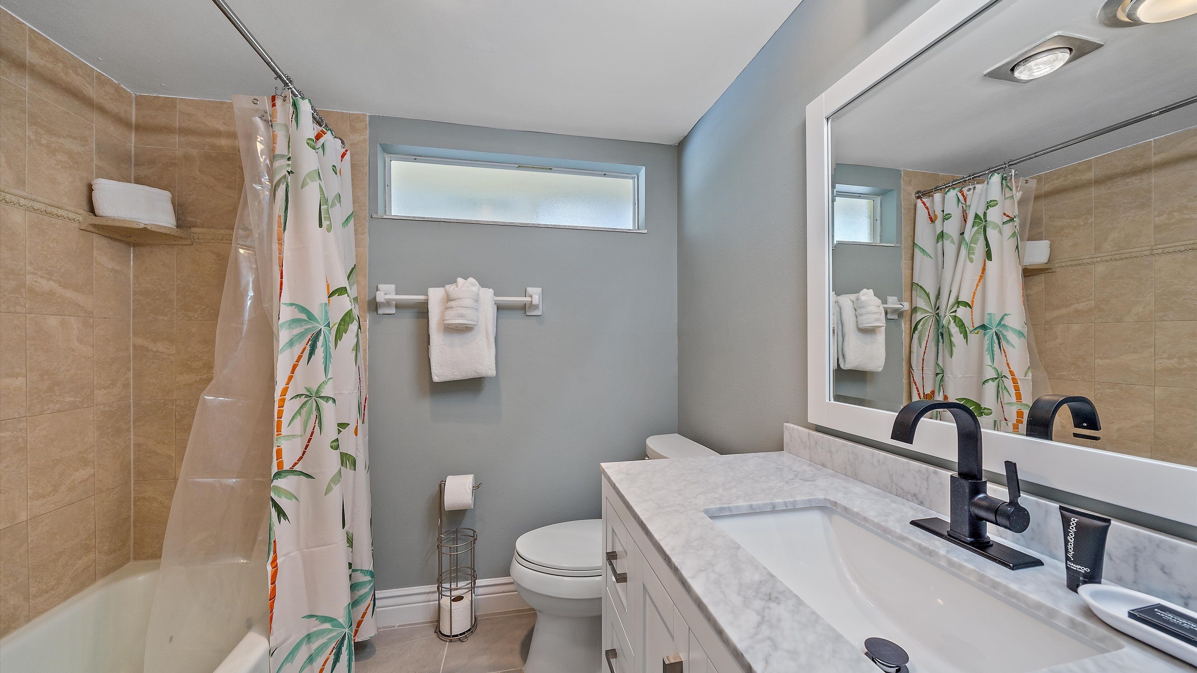 A bathroom with a bathtub, toilet, and sink.