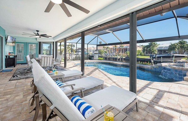 Relax by the pool in a comfortable lounge area with lounge chairs and a small table.