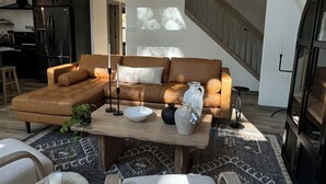 A spacious living area with a sectional sofa, a coffee table, and a large window. - Pocono Lakefront A-Frame Cabin (Pocono Lake)