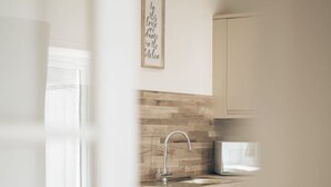 Une cuisine moderne avec un revêtement mural en bois, un évier en acier inoxydable et un coin bar.