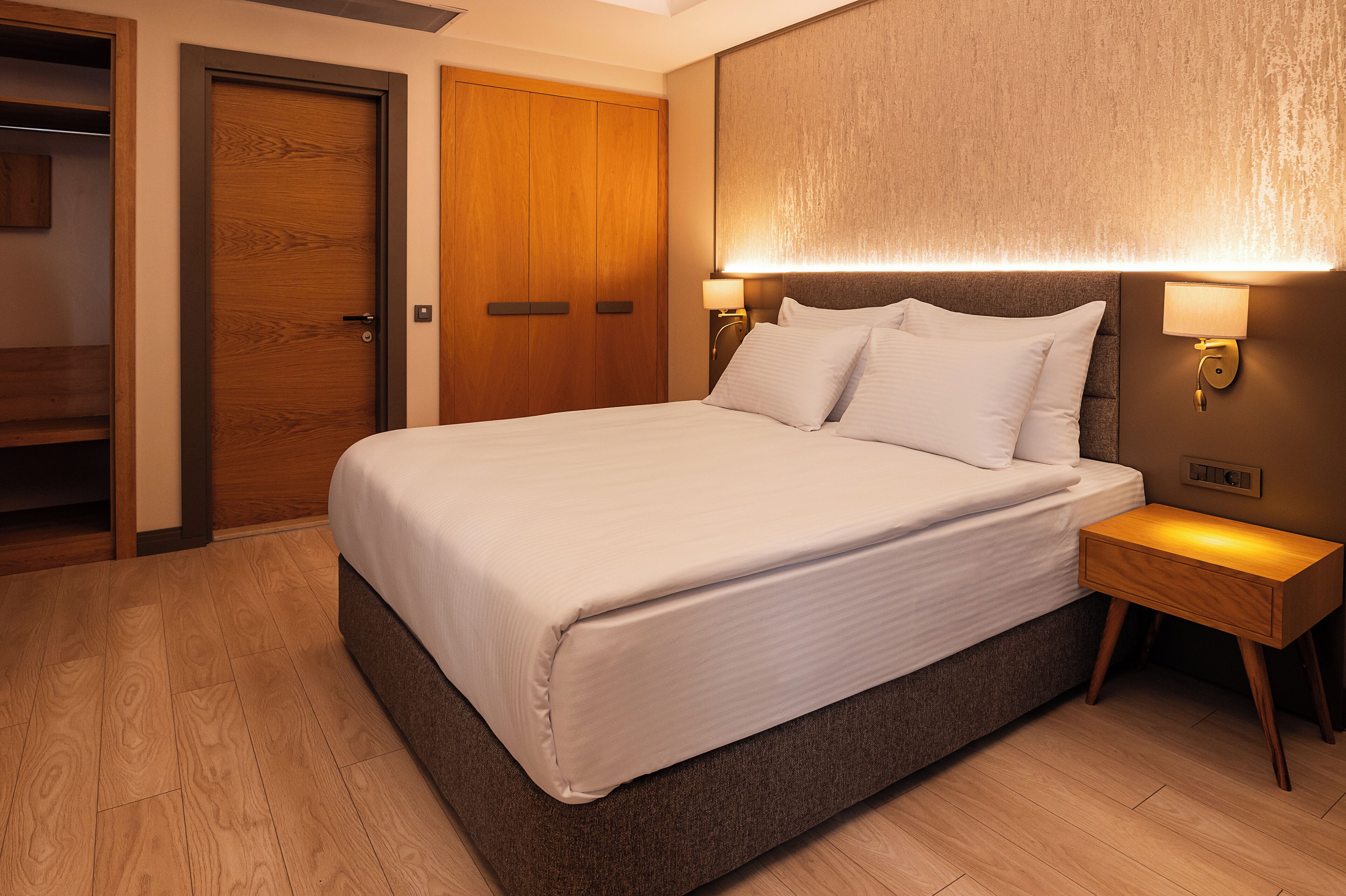 Una cama bien hecha con sábanas blancas en una habitación de hotel.