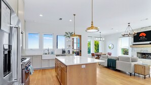 A modern kitchen with a central island, stainless steel appliances, and pendant lighting. - Hilltop Views, Dog Friendly, Deck, Fire Pit & Near Pedernales Falls (Johnson City)