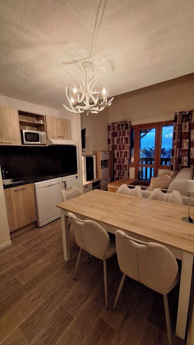Une cuisine moderne équipée d’un four à micro-ondes, d’une cuisinière et d’un coin repas avec des chaises et une table.