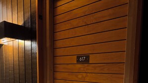 Une porte en bois portant le numéro 617, une poignée de porte et un luminaire au-dessus.