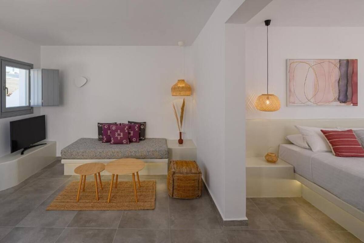 Un soggiorno moderno con divano, televisore, un tavolino e una lampada decorativa.