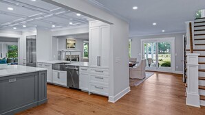Een moderne keuken met witte kasten, roestvrijstalen apparatuur en een groot eiland.