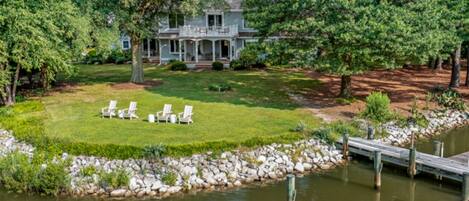 A house with a lawn, a dock, and a pond.