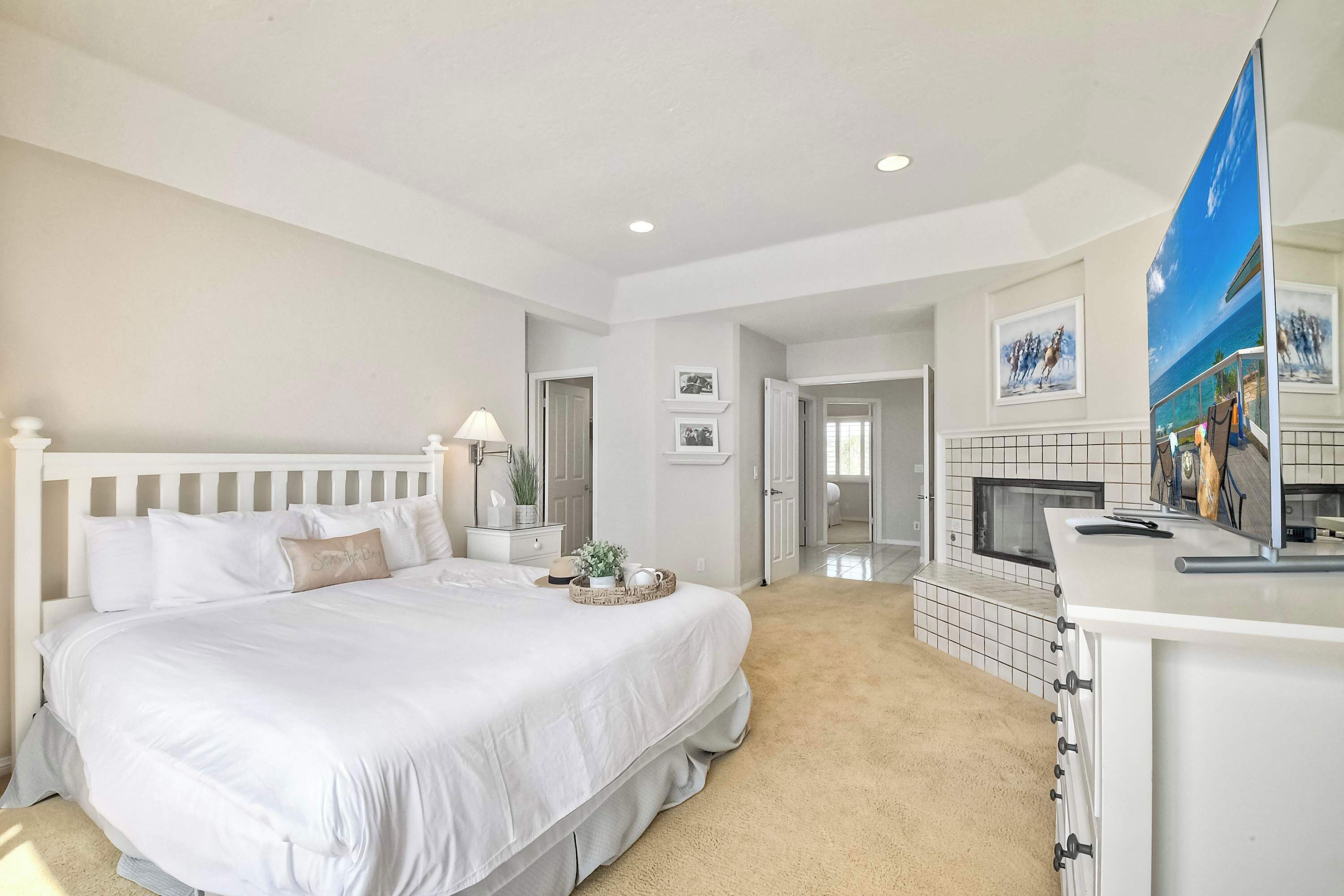 A bedroom with a large bed, bedside tables, a dresser, and a mirror.