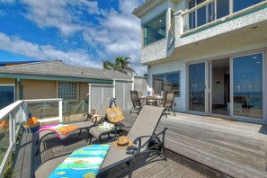 A deck with outdoor furniture, a table, and a chair.