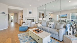 Un salon spacieux agrémenté d’un grand miroir, d’un canapé, d’une table basse et d’un coin repas offrant une vue agréable.