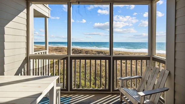 A covered porch with a view of the beach and ocean. - Birds' Nest -oceanfront condo in Dunescape Villas with beautiful views (Atlantic Beach)
