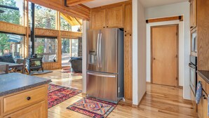 Una cocina moderna con armarios de madera, un refrigerador de acero inoxidable y un ventanal.