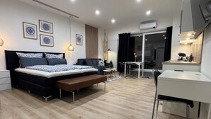 A modern bedroom with a bed, desk, and a dining area. - Marketplace atrium 1 on the ground floor (Höxter)