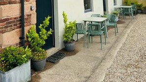 A building with a sign reading 'Town Farm Cottages' and outdoor seating. - Two bedroom Cottage in the heart of Beadnell (Beadnell)