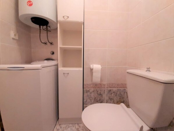 Un baño con inodoro, lavabo y ducha.