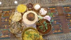 A traditional Indian meal with various dishes on a woven mat. - Rani Kutir Resort (Bolpur)