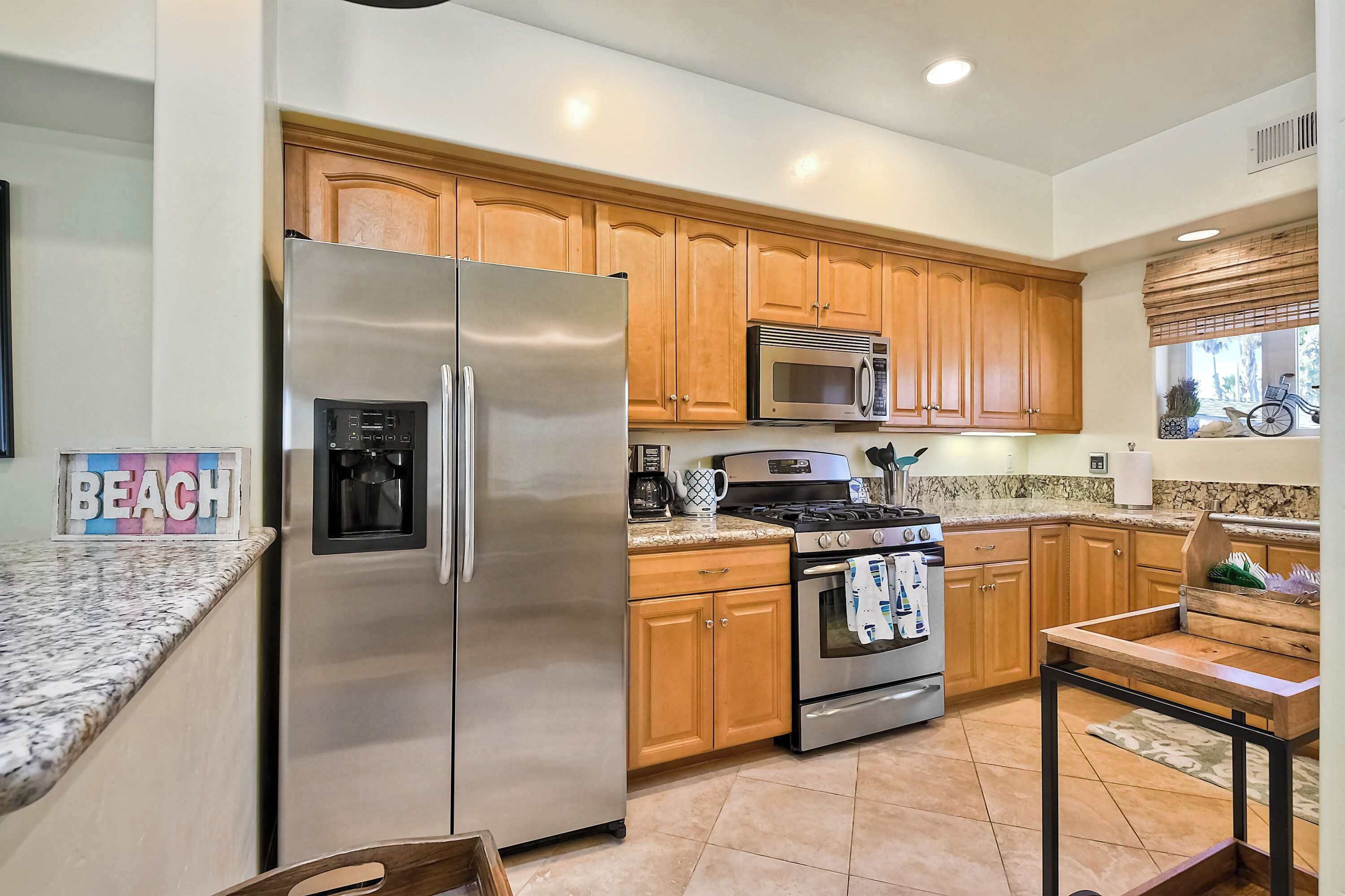 A kitchen with stainless steel appliances, wooden cabinets, a built-in oven, and a coffee maker.