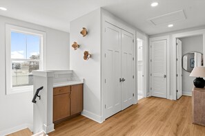 A room with a white wall, a window, a wooden cabinet, and a door. - Sunset Palms 305–Close to Gulf–Sleeps 10 (Panama City Beach)