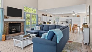 A spacious living area with a fireplace, a large sofa, and a television.