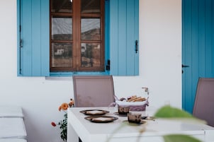 A table set with bread, a basket, and a glass.