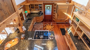 A spacious kitchen with wooden cabinets, a gas stove, and a dining area with a wooden table and chairs.