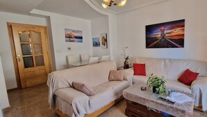 A living room with a sofa, a coffee table, a lamp, and a painting on the wall. - weforyou Solymar 2 bedrooms (Benalmádena)