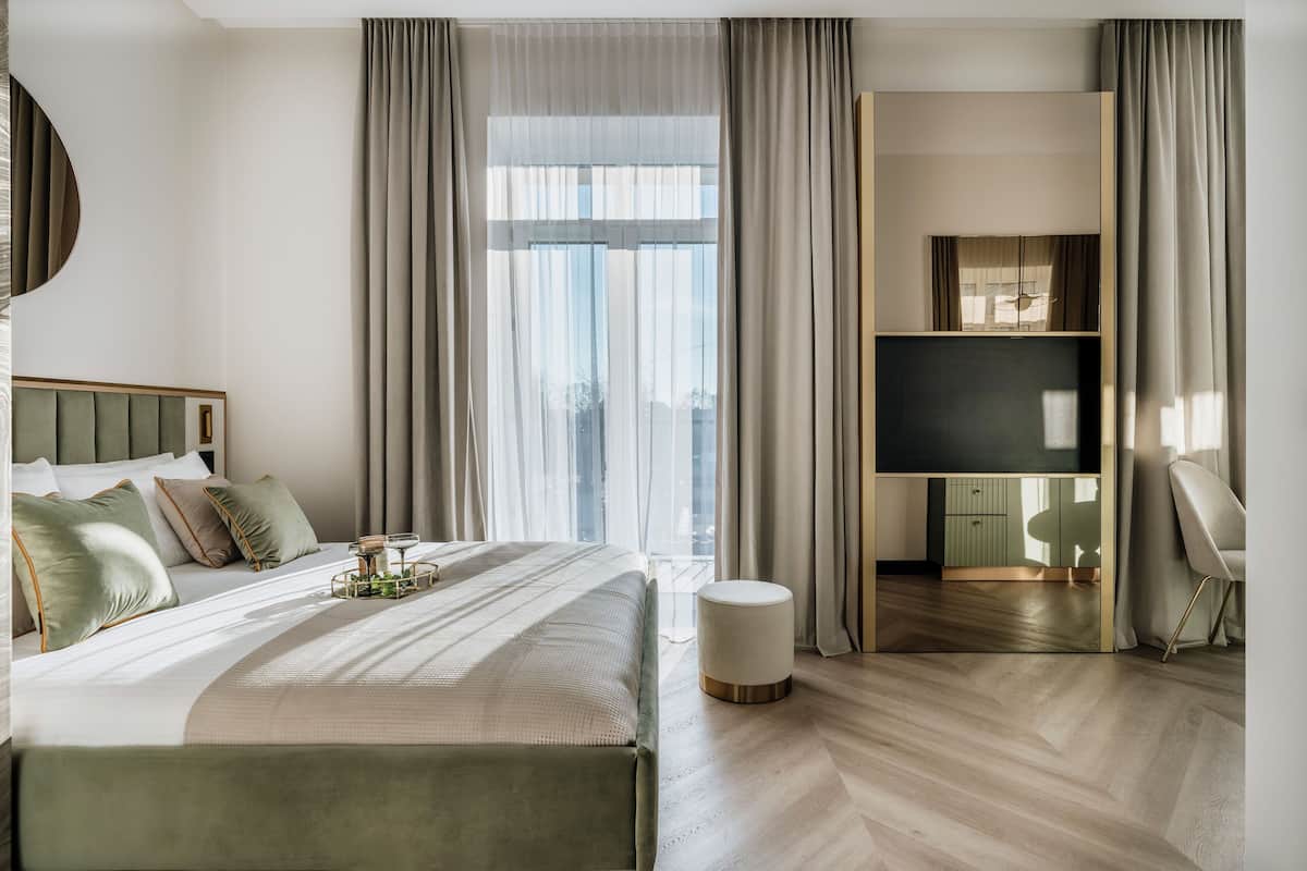 Une chambre d’hôtel moderne dotée d’un grand lit, d’une télévision et d’un coin salon.