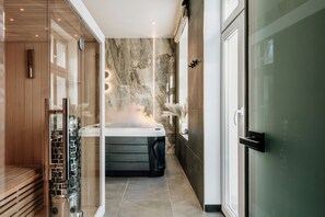 Ein moderner Wellnessbereich mit Dampfsauna, Sauna und Massageliege.