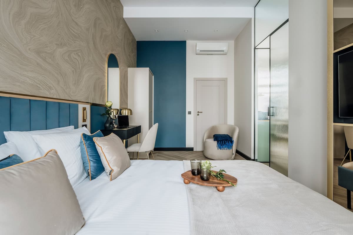 Une chambre d’hôtel moderne équipée d’un grand lit, d’un bureau, d’une chaise et d’un téléviseur.