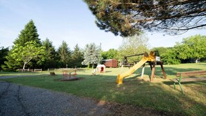 Une aire de jeux avec des balançoires et un manège.