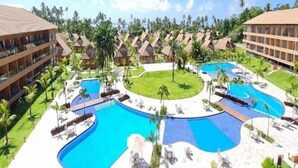 A resort with multiple swimming pools, palm trees, and resort-style buildings. - Eco Resort Praia dos Carneiros  (Tamandaré)