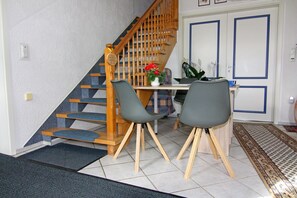 Cozy living space with a functional layout, featuring a staircase, dining area, and comfortable seating.