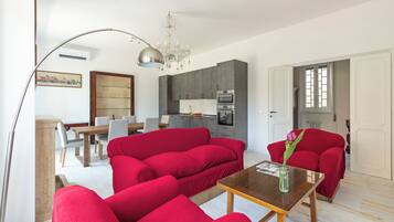 Relax in a stylish living room with a large sofa, coffee table, and elegant chandelier.