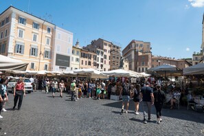 A bustling outdoor market with people walking and vendors selling goods. - Campo De Fiori Large Family Apartment (Rome)