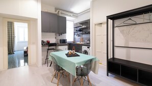 A compact kitchen with modern appliances, a dining area with a table and chairs, and a map on the wall. - Cozy And Comfy Apartment At Esquilino (Rome)