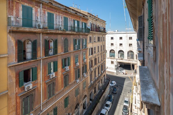 Un estrecho callejón entre edificios de varios pisos, con balcones y unidades de aire acondicionado.
