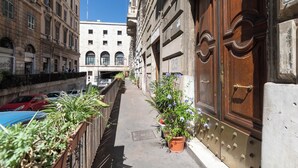A narrow alleyway with a wooden door and potted plants. - Cozy And Comfy Apartment At Esquilino (Rome)