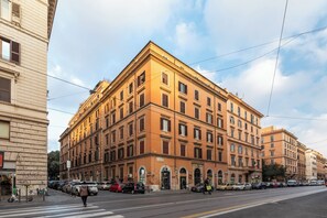 A multi-story building with a classic architectural style, featuring arched doorways and a symmetrical facade.