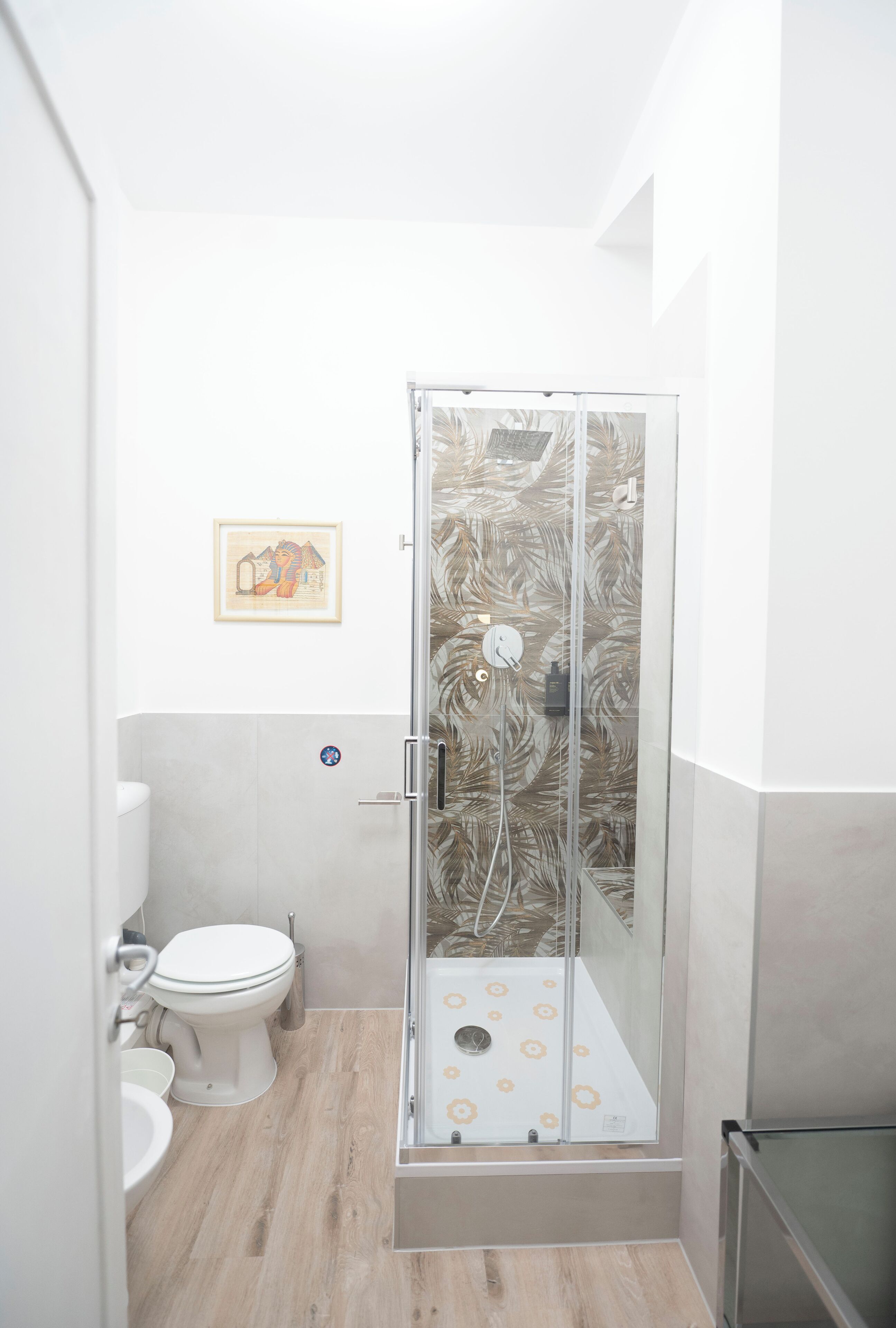 Une salle de bain avec une douche à parois de verre, des toilettes et un lavabo.