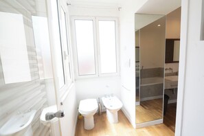 Ein modernes Badezimmer mit Toilette, Bidet und Waschbecken.