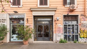 Eine Gebäudefassade mit einem Laden namens "ARITI DA LAVORO" und einem weiteren namens "OTTICA SAN LORENZO".