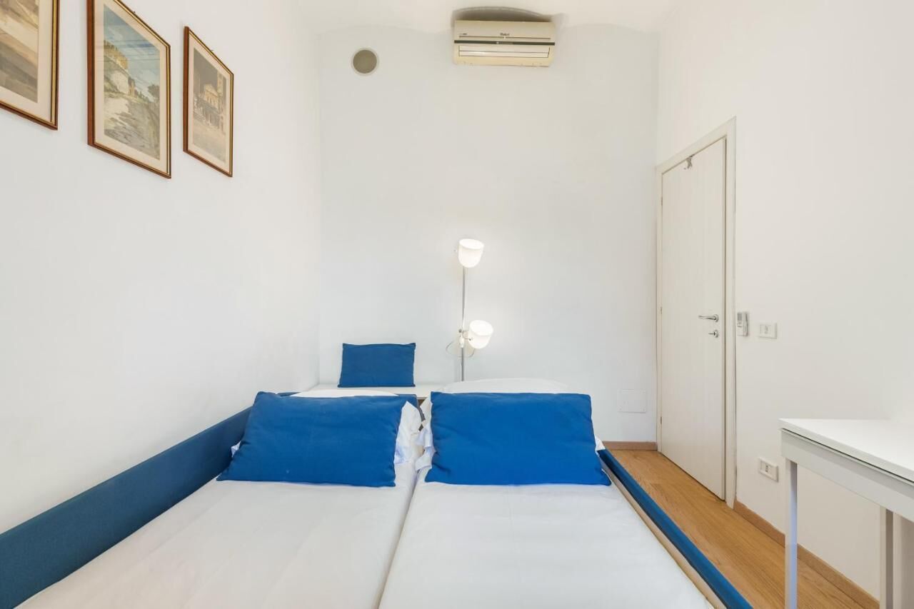 A room with two beds, a desk, and a wardrobe.