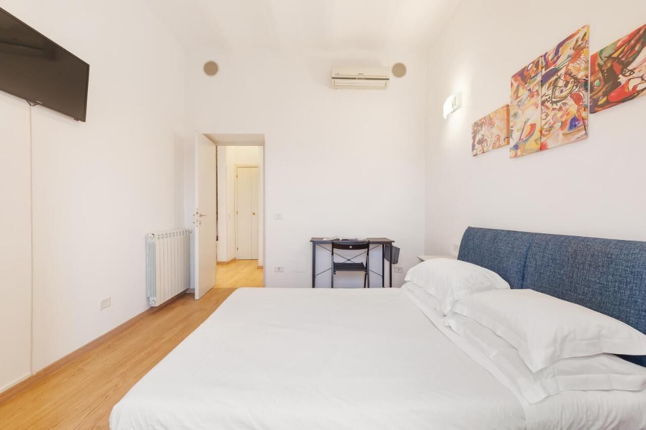 Un dormitorio con cama, escritorio y radiador.