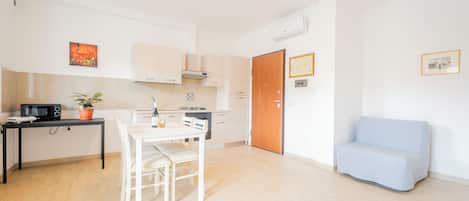 A compact living space with a kitchenette, a dining area, and a seating area.