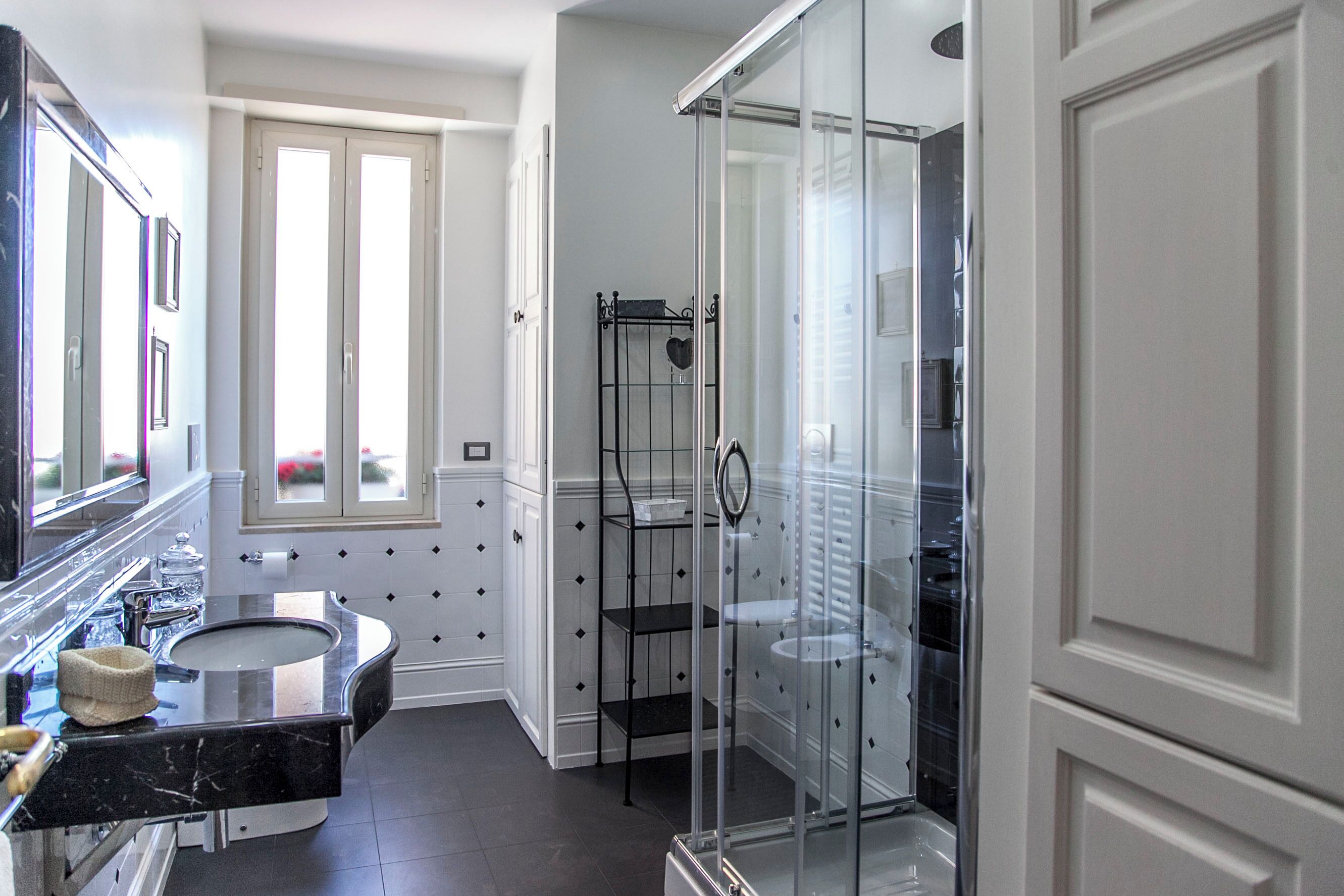 Une salle de bain moderne avec un lavabo aux lignes courbes, une douche en verre et un meuble-lavabo doté d’un miroir.