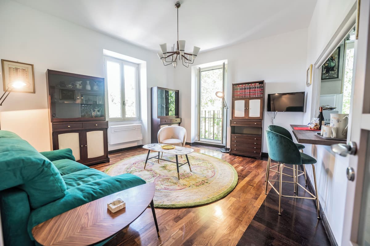 Una sala moderna con sofá, mesa de centro, televisor y un comedor con sillas.